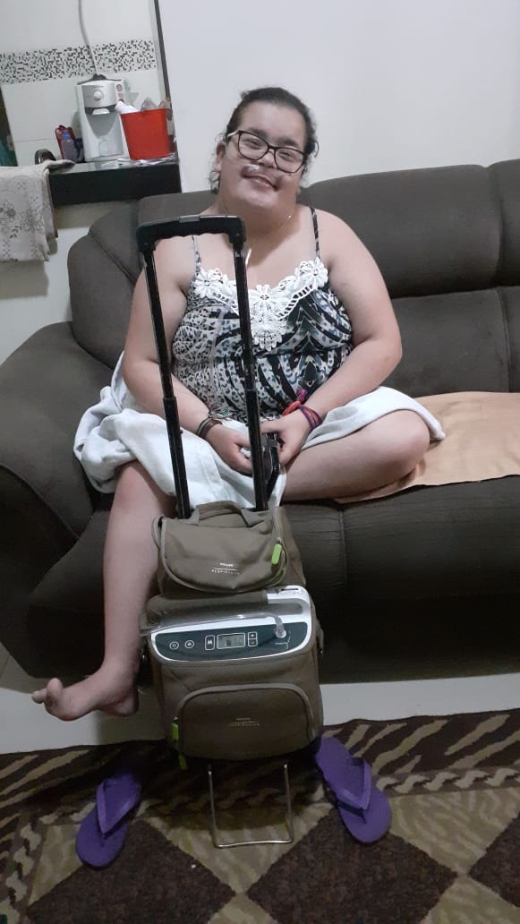 Talita com o aparelho portátil após o conserto